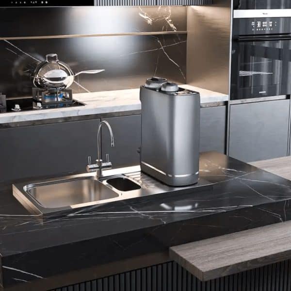 Sleek modern kitchen with black marble countertops, stainless steel sink, water purifier, and built-in appliances, showcasing contemporary design and high-quality materials.